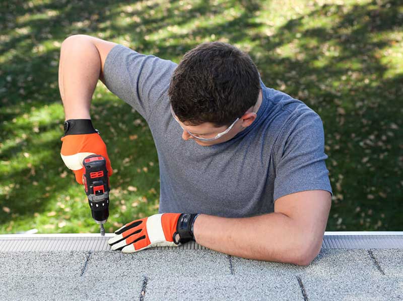 Streamline Exteriors tech installing gutter guard